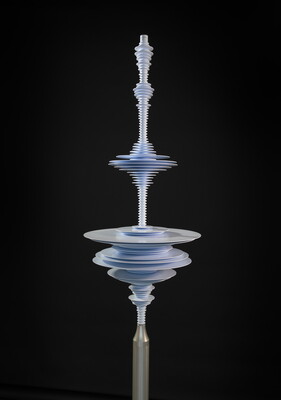 A vertical silver, metal sculpture of a sound wave composed of a stack of different sized discs.