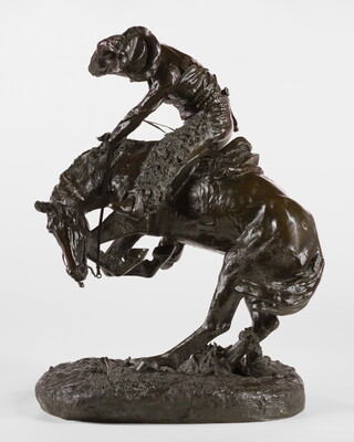 A sculpture of a man riding a bucking horse around a rattlesnake.