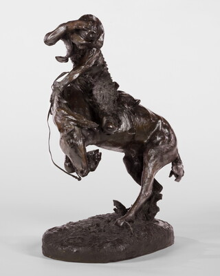 A sculpture of a man riding a bucking horse around a rattlesnake.