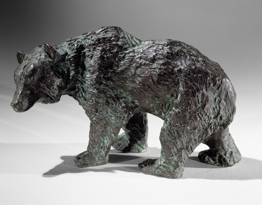 A bronze sculpture of a walking bear.