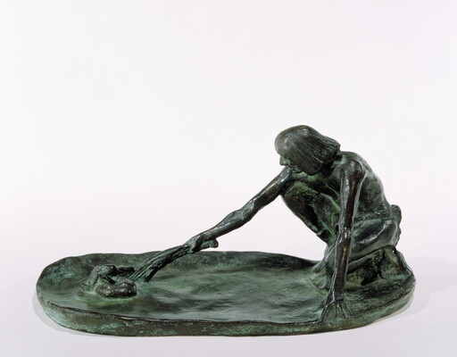A bronze sculpture of a squatting Indigenous man holding a stick in his outstretched arm toward a snake on the ground.