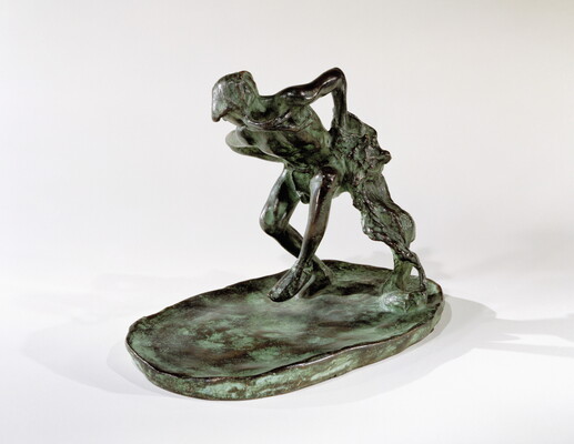 A bronze sculpture of an Indigenous man dancing with a wolfskin in his hand.