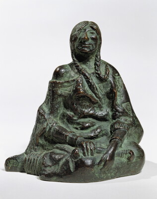 A bronze sculpture of a seated Native American person wrapped in a robe.