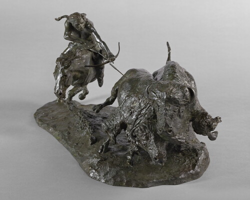 A sculpture of a Native American on horseback using a bow and arrow to hunt two bison.