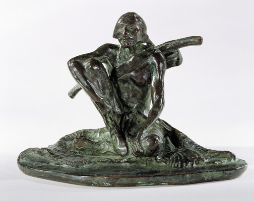A bronze sculpture with a slight green patina of an Indigenous man seated on the ground.