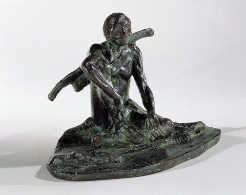 A bronze sculpture with a slight green patina of an Indigenous man seated on the ground.