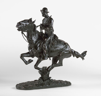 A bronze sculpture of a cowboy riding a galloping horse and holding a pistol close to his chest.