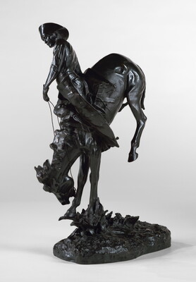 A bronze sculpture of a cowboy hanging onto a bucking bronco.