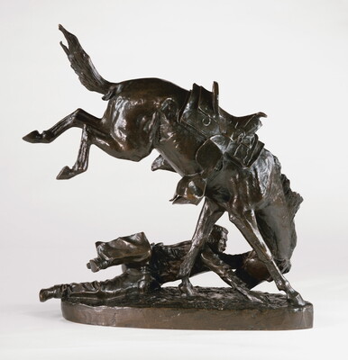 A bronze sculpture of a man on the ground hanging on to the head of his bucking horse.