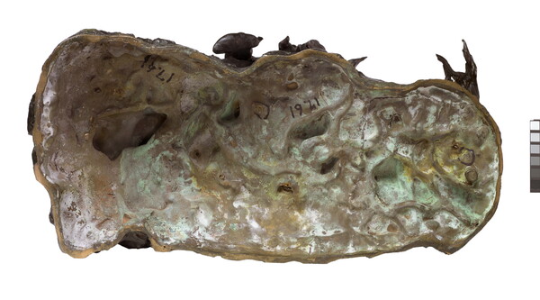 A bronze sculpture of a man on horseback holding a piece of scalp and hair in his hand thrusted above his head triumphantly.