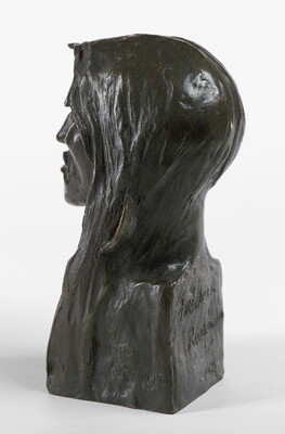 A bronze bust of an Indigenous man with long hair.