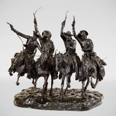 A bronze sculpture of four cowboys riding horses while holding their guns high in the air.