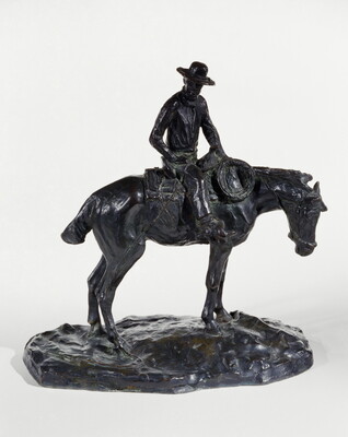A bronze sculpture of a man wearing a cowboy hat seated on a standing horse.