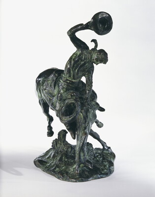 A bronze sculpture of a cowboy trying to ride a bucking horse.