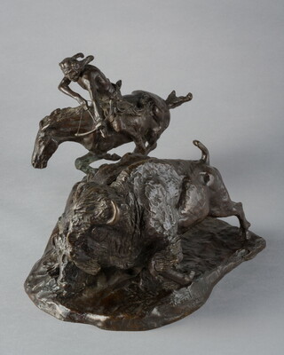 A bronze sculpture of a Native American on horseback hunting bison with a bow and arrow.