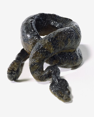 A painted sculpture of a coiled, multicolored rattlesnake.