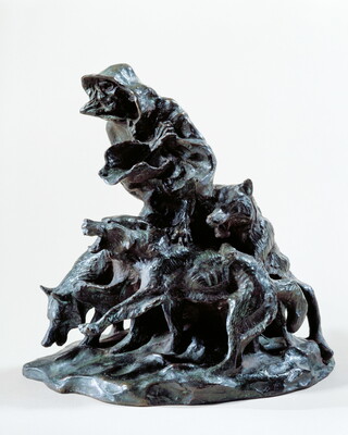 A bronze sculpture of an emaciated person wrapped in blankets surrounded by three snarling wolves.