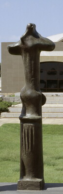 A tall, vertical, bronze sculpture of organic forms atop a geometrically carved base.