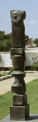 A tall, vertical, bronze sculpture of organic forms atop a geometrically carved base.