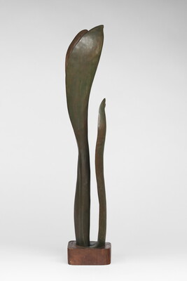 A wood sculpture of a tall, thin leaf with two smaller leaves on either side.