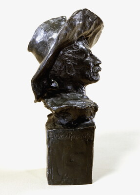 A bronze bust of a mustached man wearing a cowboy hat and a kerchief around his neck.
