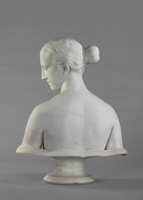 A marble bust of a bare-breasted woman.