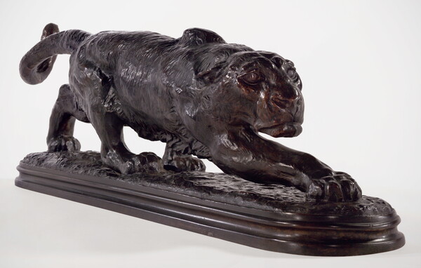 A bronze sculpture of a crouching panther with elongated body and front leg outstretched.