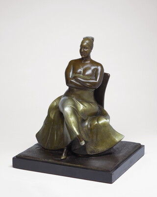 A bronze sculpture of a woman wearing an evening gown sitting with her legs and arms crossed.