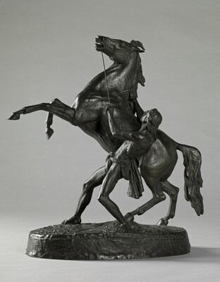 A bronze sculpture of a Native American man holding back a rearing horse.