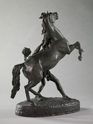 A bronze sculpture of a Native American man holding back a rearing horse.