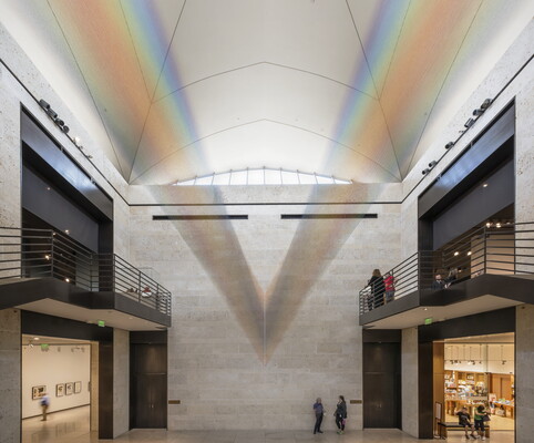 A large installation of multicolored sewing thread that stretches from one wall to the ceiling in the Carter's Atrium and looks like a rainbow.