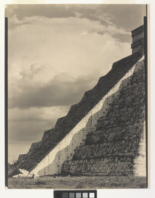 A black-and-white photograph of the diagonal corner edge of a Mayan step-pyramid.