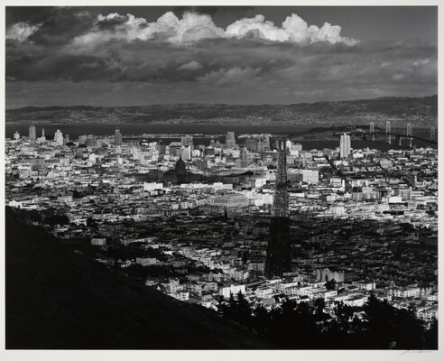 A black-and-white photograph of an arial view of San Francisco, parts of which are in shadow from clouds.