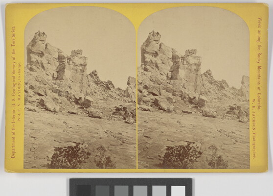 A sepia-toned stereograph of a tall rock formation.