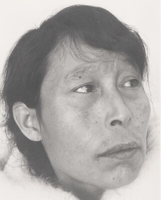 A black-and-white photograph of a close-up of an Indigenous woman with short dark hair and some freckles.