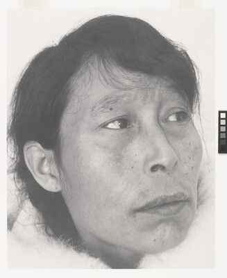 A black-and-white photograph of a close-up of an Indigenous woman with short dark hair and some freckles.