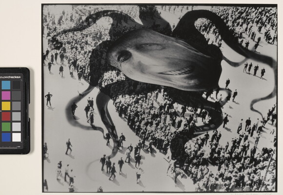 A black-and-white photograph of a distorted face superimposed over the shadow of an octopus hovering above a crowd of people.