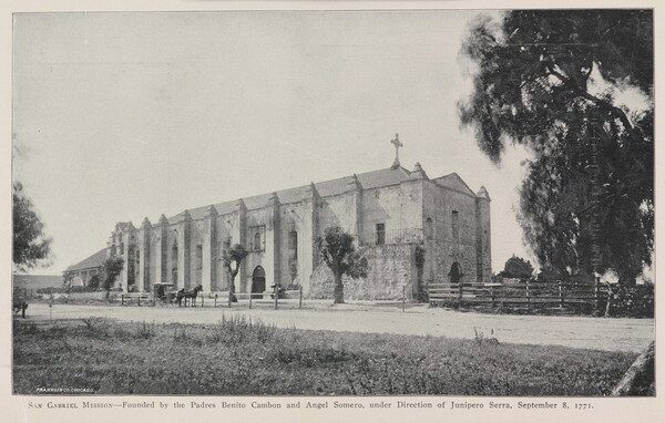 A black-and-white photograph of a mission church by a dirt road.