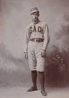 A black-and-white studio photograph of a young White man wearing a baseball uniform with the letters "GAC" on the front of his jersey.