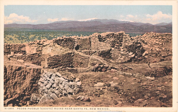 A color postcard of a ruined, stone building with multiple rooms in a mountainous landscape.