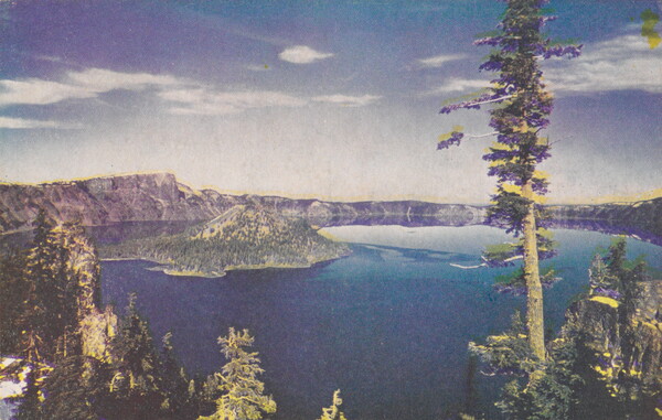 A color postcard print of a blue lake with trees in the foreground, cliffs in the background, and an island rising up from the water.