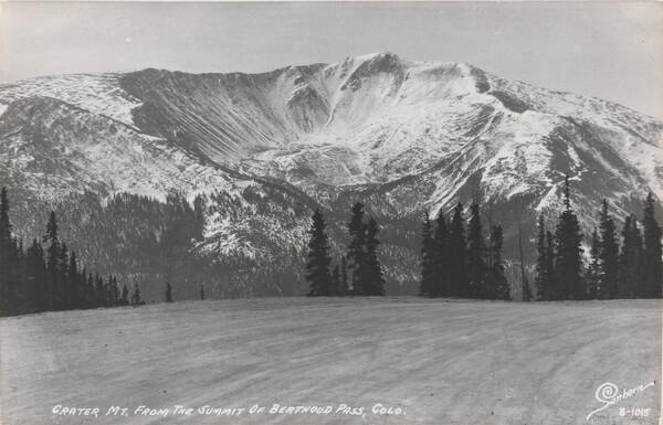 A black-and-white postcard of a crater in a large, snowy mountain.