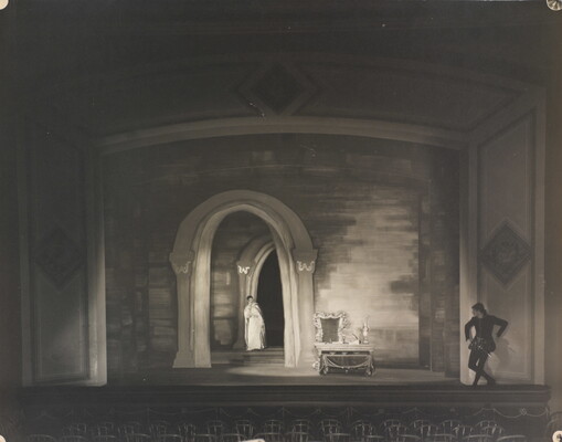 A black-and-white photograph of a woman and man performing on a stage.