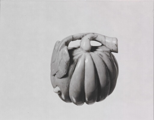 A black-and-white photograph of a ceramic pumpkin.