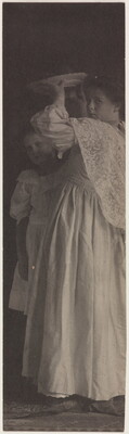A very vertically-oriented black-and-white photograph of two White girls in formal dresses, one holding a plate above her head.