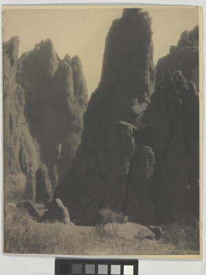 A black-and-white photograph of large hoodoos, or vertical spires of rock.