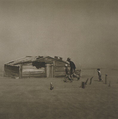 A black-and-white photograph of a man and two children walking through a dust storm by a dilapidated structure.