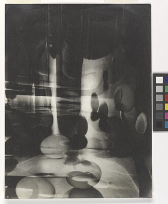 A black-and-white photograph of abstracted egg shapes layered and reflected on top of one another.