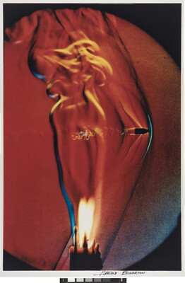 A color photograph of a lit candle with a bullet going through the flame.