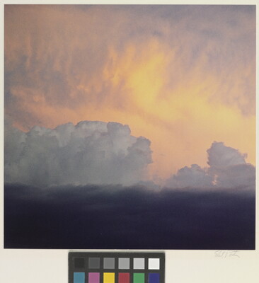 A color photograph of clouds: dark at the bottom, billowing white clouds in the middle, and soft gold and orange clouds at the top.